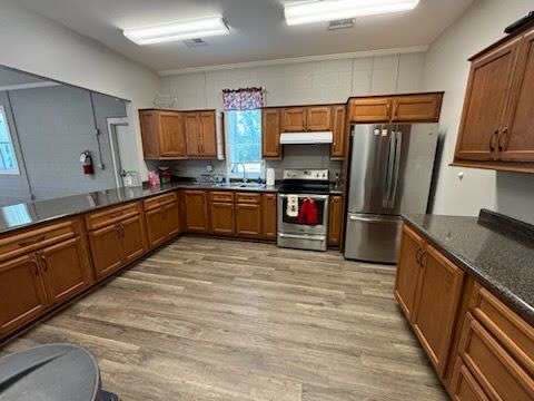 The Post 206 full kitchen with wood cabinets, a stainless steel range and a stainless steel refrigerator