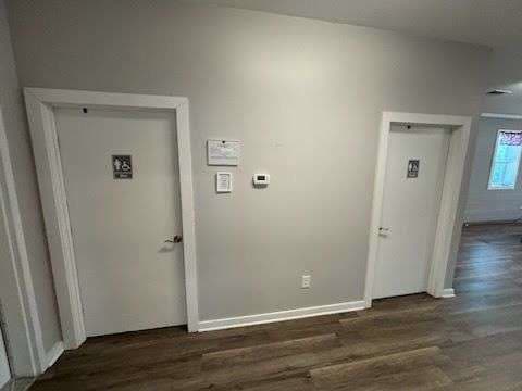 An interior corridor at Post 206 with two restroom doors and a wall thermostat