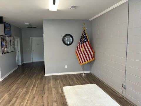 The Post 206 event room, painted cinder-block walls and wood-look flooring, with a United States flag on a floor stand and notice boards on the wall